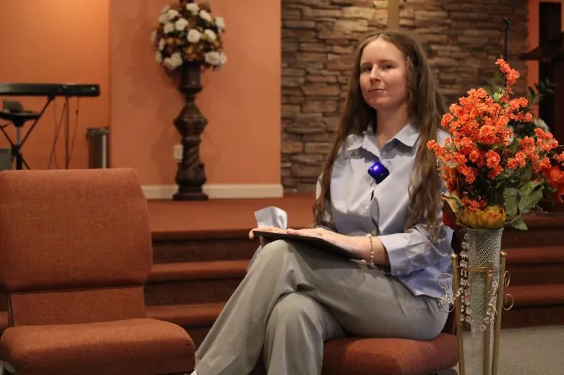 Charlotte Liberis, seated in a church sanctuary.